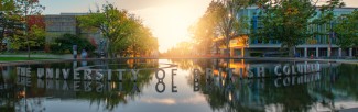 A picture of a fountain with "University of British Columbia" on it with a sunset in the background.
