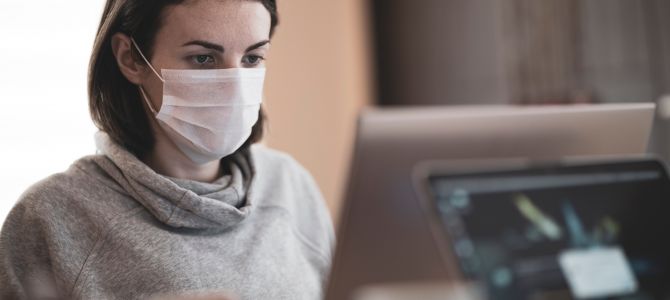 Woman wearing mask at a computer